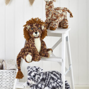 Two knitted giraffe stuffed animals perched on a white ladder in a cozy nursery scene with burlap bunting behind them.