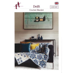 Living room scene with a black sofa draped in a blue-and-white crochet blanket, flanked by teal and yellow cushions and a console table with vases in the background.