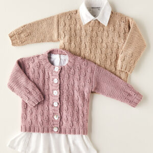 Two children's knit sweaters laid flat: a pink cardigan with white buttons over a white blouse, and a beige cable-knit sweater with a white collar beneath.